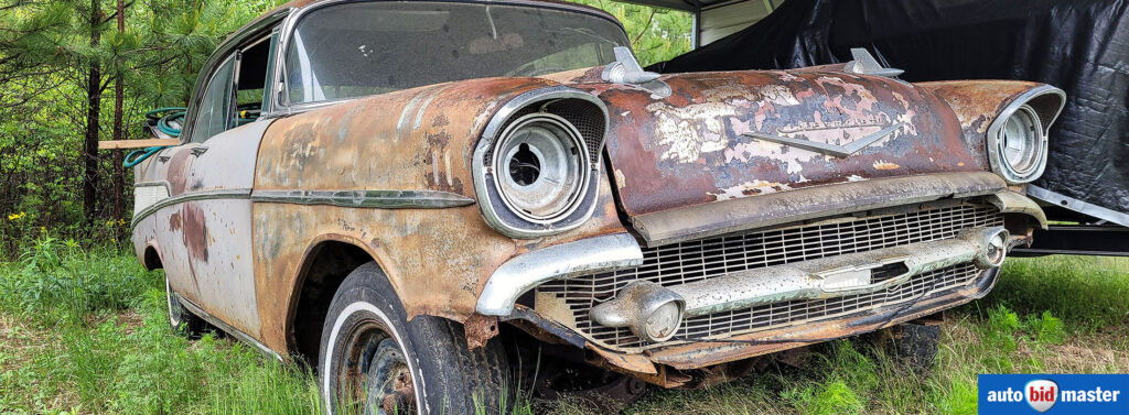 Old car found in a dump that needs repair.