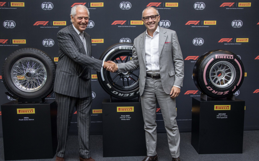 Pirelli Tire and Formula One representatives shake hands at deal signing