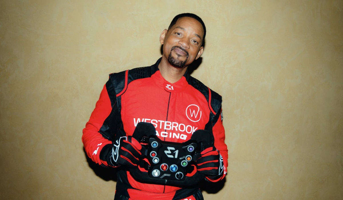 Will-Smith-posing-with-E1-Racing-Series-Steering-Wheel-shared-by-AutomotiveWoman.com