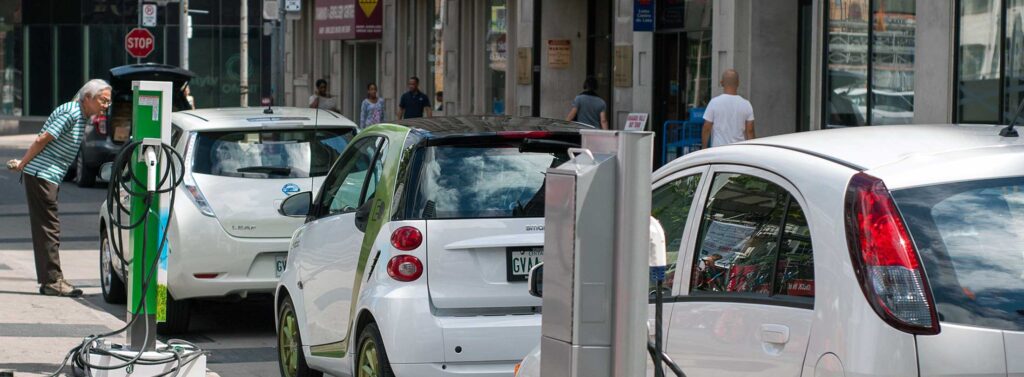 Male consumer looking in an electric vehicle. Shared by AutomotiveWoman.com